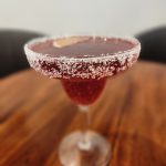 Red cocktail with sugar around the lip of the glass